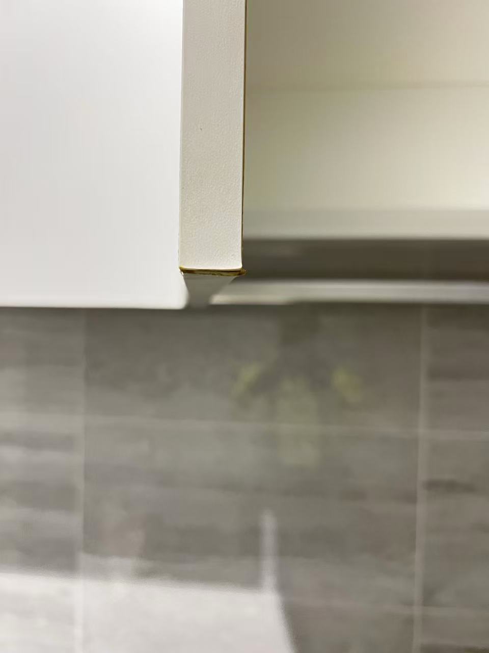Close-up of the exposed lower edge of an open cupboard door
