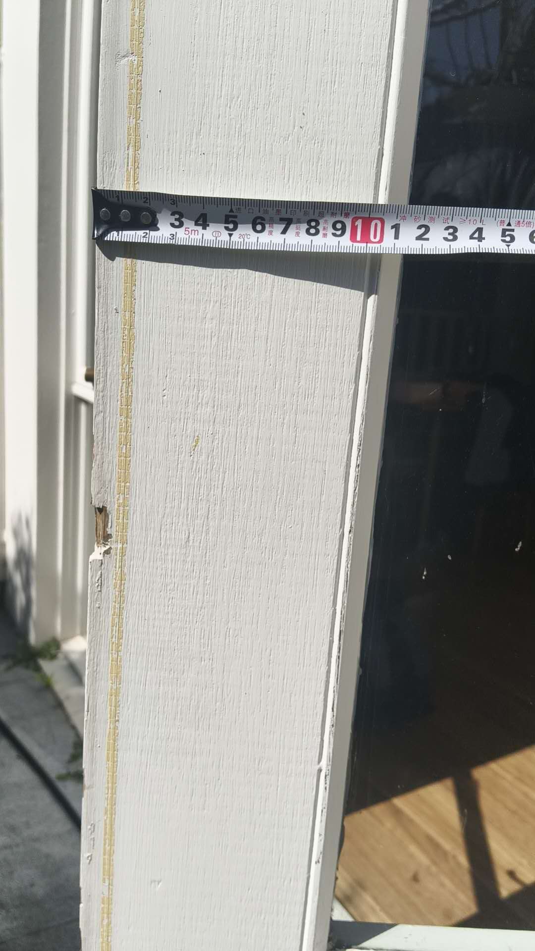 Close view of a door jamb beside a tape measure